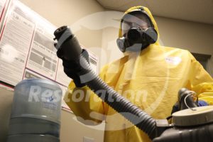 Restoration technician in protective gear performing cleaning work on a crime scene cleanup job in San Diego